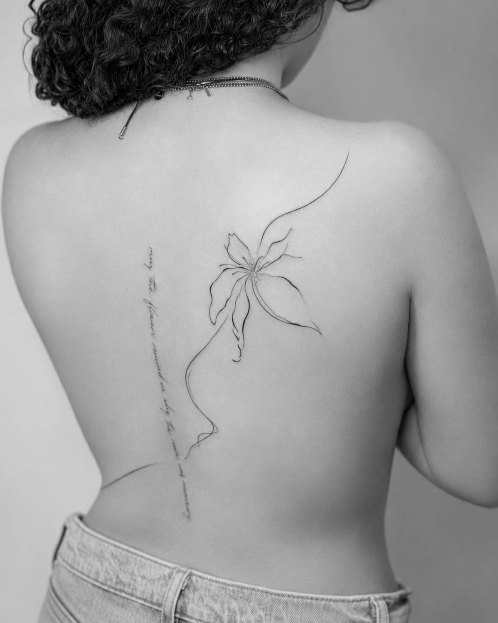 Fineline Rücken Tattoo mit Blume in Kassel